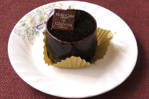 黒いチョコレートグラサージュでコーティングされた、円筒形のケーキ。