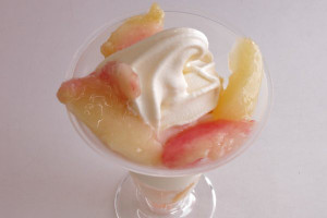 くし形にカットされたたっぷりの完熟白桃とバニラソフトクリームが盛りつけられたパフェ。