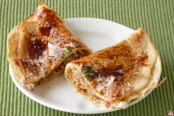 薄焼きの生地で焼きそばをくるみ、ソースを塗ってカツオ節と青のりを散らしてある。