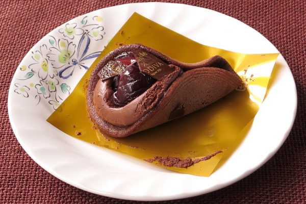 チョコ色のワッフルでチョコクリームを包み、チェリーやソースとともにチョコプレートをトッピング。