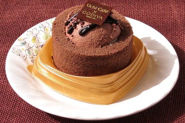 チョコ色のプレミアムロールケーキの上にドーム状のチョコムースとトッピングを盛った形。