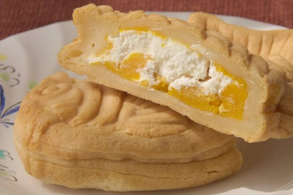 もっちり生地のお腹の中には純白のホイップとオレンジのかぼちゃクリーム。