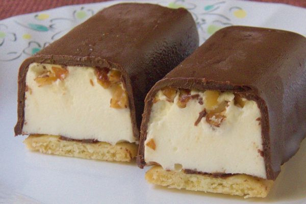 底にはクッキーが敷かれ、内側は純白のムース、コーティングの下にはクラッシュアーモンド。