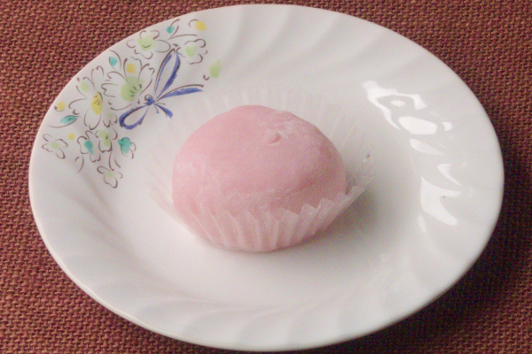 薄く打ち粉を纏ったパステルピンクの大福。