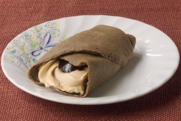 こげ茶色のクレープ生地で、クリームとソースを巻き上げてあります。
