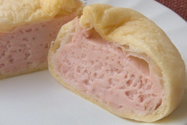 薄手のシューの中にはパステルピンクのクリームが充満しています。